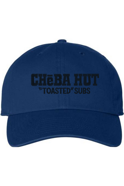 A royal blue baseball cap with a curved brim. The front of the cap features the black stylized text 'CHEBA HUT "TOASTED" SUBS' embroidered across the center. The cap has a visible button on the top and an adjustable strap in the back (not visible).
