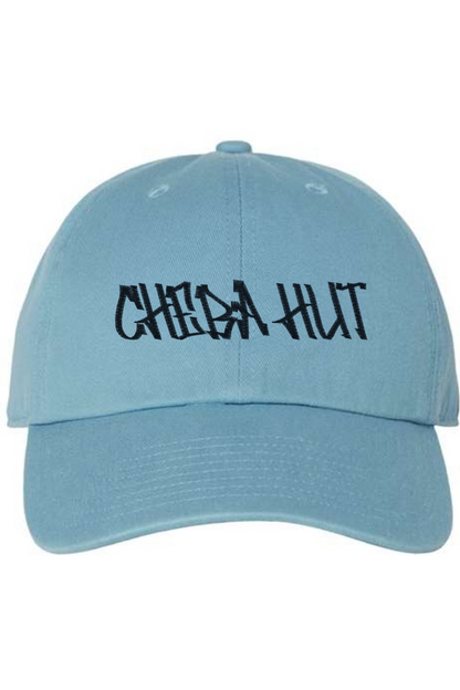 A light blue baseball cap with a curved brim. The front of the cap features the black stylized text 'CHEBA HUT' embroidered across the center. The cap has a visible button on the top and an adjustable strap in the back (not visible).