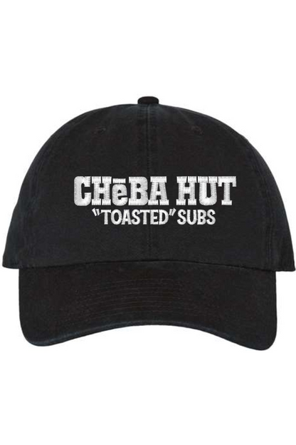 A black baseball cap with a curved brim. The front of the cap features the white stylized text 'CHEBA HUT "TOASTED" SUBS' embroidered across the center. The cap has a visible button on the top and an adjustable strap in the back (not visible).