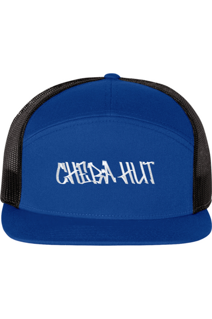 A seven -panel trucker hat with a solid royal blue front panel and brim. The back two panels are black mesh. The front of the hat features the white stylized text 'CHEBA HUT'. The hat has a slightly curved brim and a visible button on the top.
