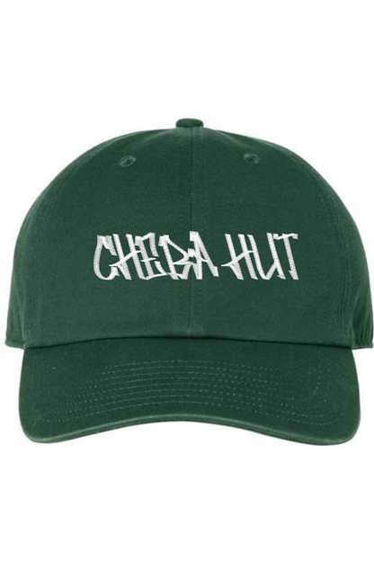 A dark green baseball cap with a curved brim. The front of the cap features the white stylized text 'CHEBA HUT' embroidered across the center. The cap has a visible button on the top and an adjustable strap in the back (not visible).