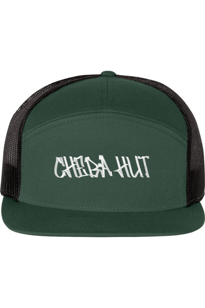 A seven -panel trucker hat with a solid dark green front panel and brim. The back two panels are black mesh. The front of the hat features the white stylized text 'CHEBA HUT'. The hat has a slightly curved brim and a visible button on the top.