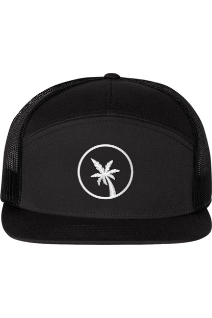 A seven -panel trucker hat with a solid black front panel and brim. The back two panels are black mesh. The front of the hat features a seven frond palm tree in white thread. The hat has a slightly curved brim and a visible button on the top.