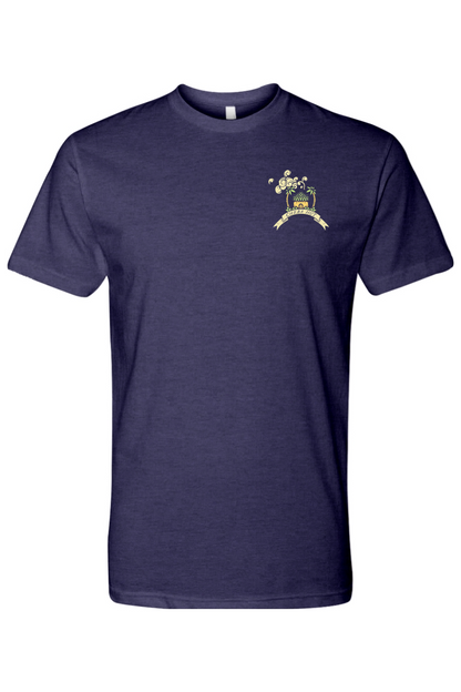 A dark purple short-sleeved t-shirt featuring a small, colorful graphic on the left chest of a small hut with a palm tree on either side. 