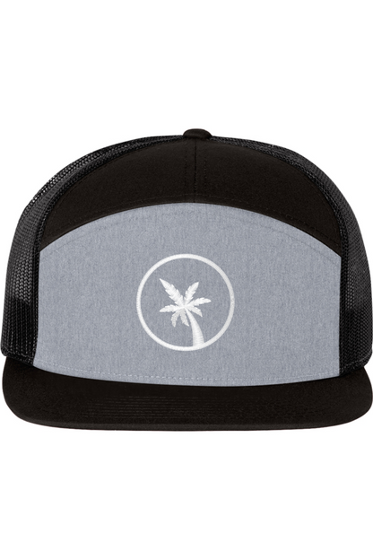 A seven -panel trucker hat with a solid grey front panel and a black top panel and brim. The back two panels are black mesh. The front of the hat features a seven frond palm tree in white thread. The hat has a slightly curved brim and a visible button on the top.