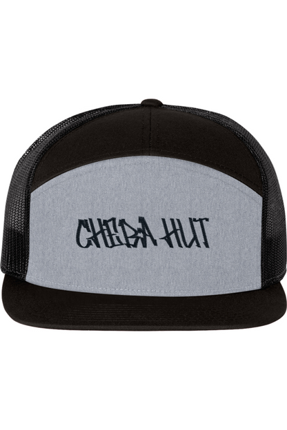 A five-panel trucker hat with a solid light grey front panel and brim. The back two panels are black mesh. The front of the hat features the black stylized text 'CHEBA HUT'. The hat has a slightly curved brim and a visible button on the top.