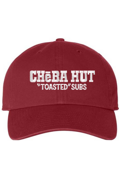 A cardinal red baseball cap with a curved brim. The front of the cap features the white stylized text 'CHEBA HUT "TOASTED" SUBS' embroidered across the center. The cap has a visible button on the top and an adjustable strap in the back (not visible).