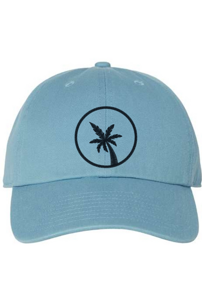 A blue baseball cap with a curved brim. The front of the hat features an embroidered seven frond Palm Tree in black thread. The cap has a visible button on the top and an adjustable strap in the back (not visible).