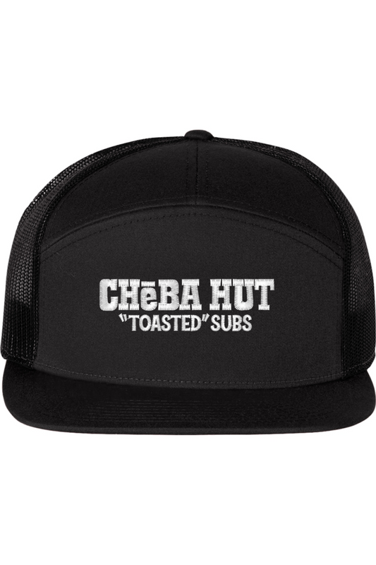 A seven -panel trucker hat with a solid black  front panel and brim. The back two panels are black mesh. The front of the hat features the white stylized text 'CHEBA HUT "TOASTED" SUBS'. The hat has a slightly curved brim and a visible button on the top.