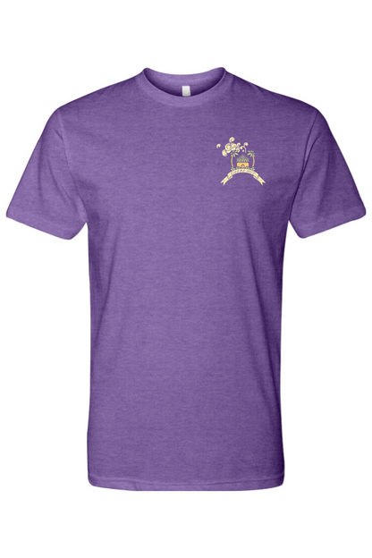 A purple short-sleeved t-shirt featuring a small, colorful graphic on the left chest of a small hut with a palm tree on either side. 