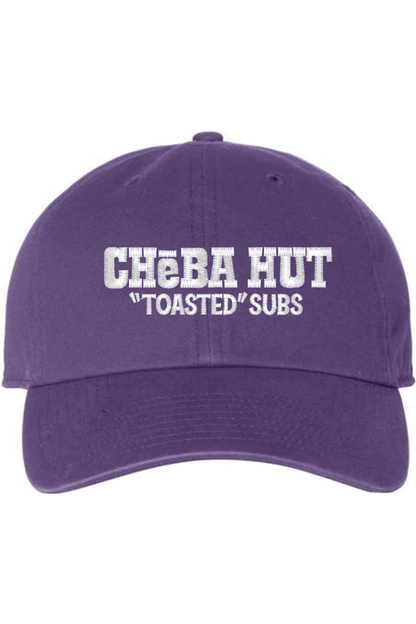 A purple baseball cap with a curved brim. The front of the cap features the white stylized text 'CHEBA HUT "TOASTED" SUBS' embroidered across the center. The cap has a visible button on the top and an adjustable strap in the back (not visible).